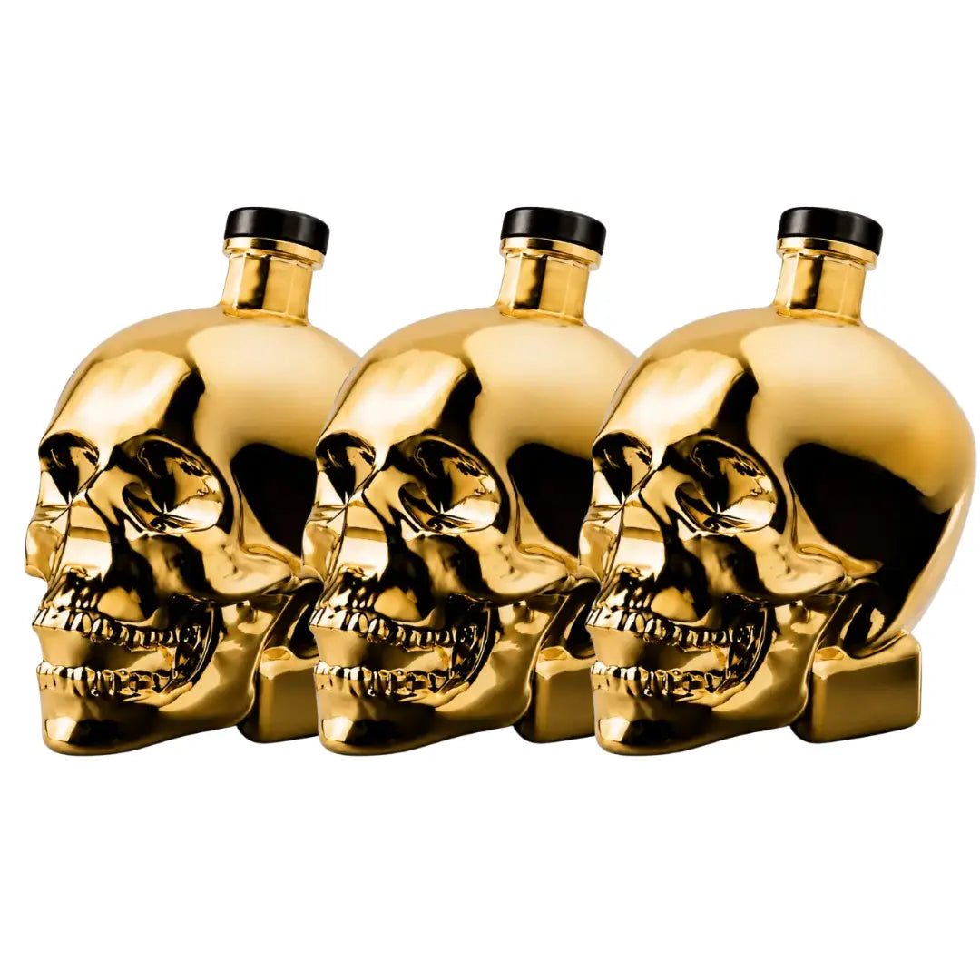 Three black-capped gold skull bottles of Crystal Head Vodka Gold Edition (Pre-Order) from Crystal Head Vodka are arranged in a row against a white background—an impressive showcase of this premium Canadian vodka.