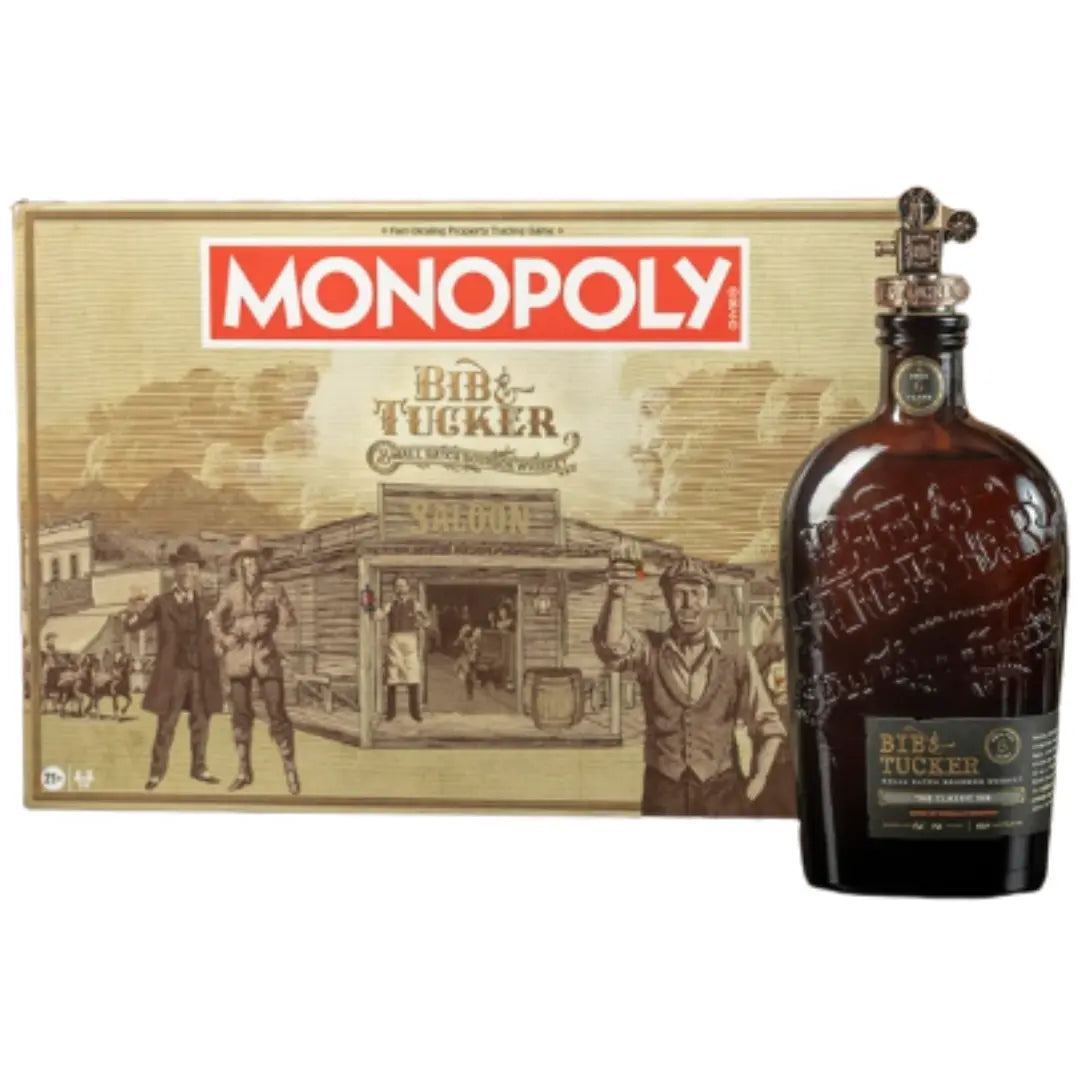 The Bib &amp; Tucker MONOPOLY Collector’s Edition Bourbon &amp; Board Game Bundle box featuring a Western saloon scene next to a bottle of Bib &amp; Tucker Bourbon with a metal game piece stopper.