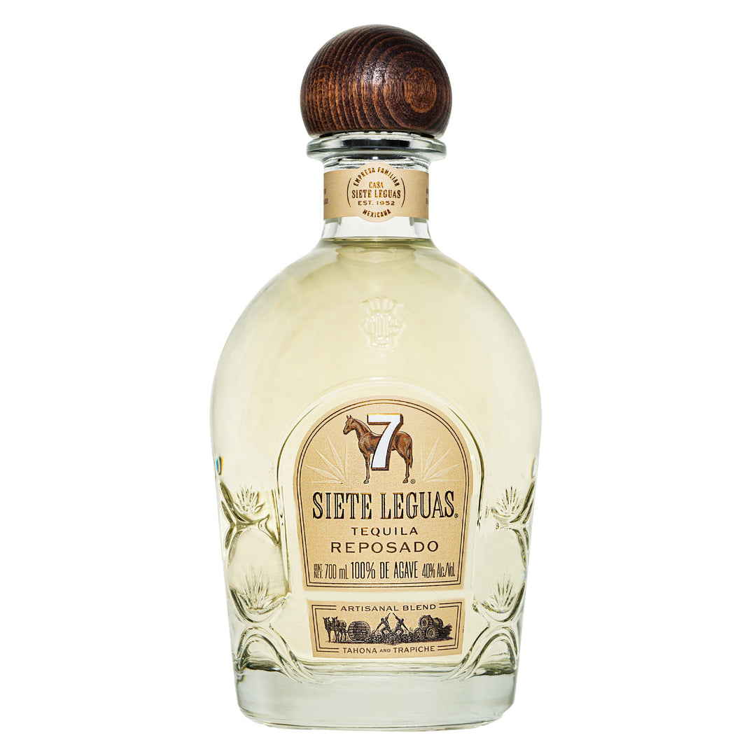 A glass bottle of Siete Leguas Reposado features a wooden cap, a beige label with a horse and the number 7, and holds light golden tequila.