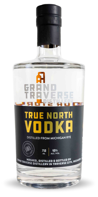 A clear glass bottle of Grand Traverse Distillery True North Rye Vodka with a black cap, featuring a label that displays the brand name and details about Michigan rye, alcohol content, and bottle size.