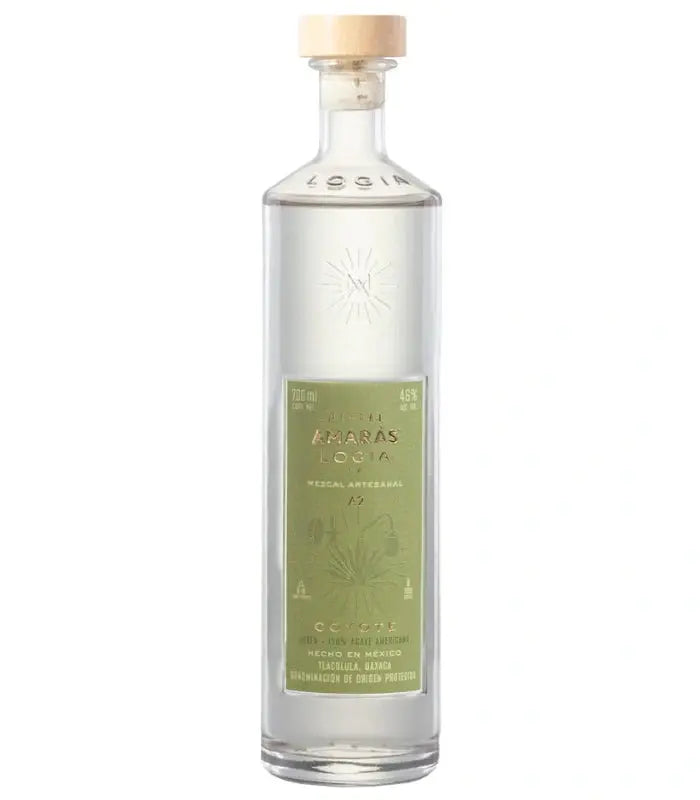 A clear 700mL glass bottle of Amaras Mezcal Joven Logia Ma Coyote A2, featuring a light wooden cap and green label with agave illustrations, contains 46% alcohol.