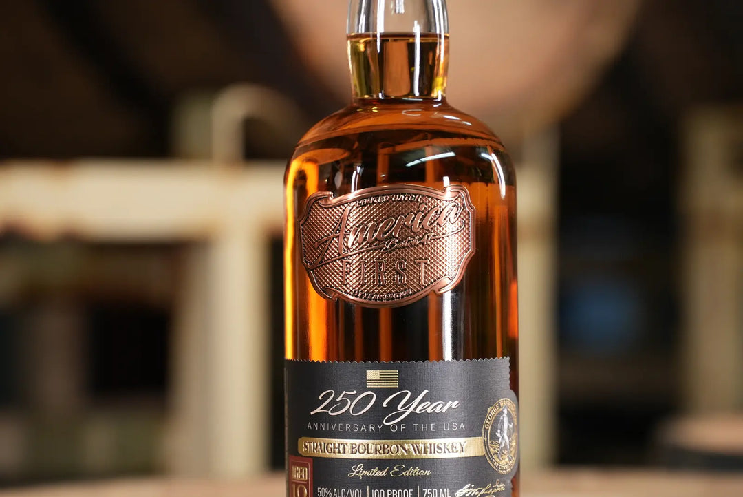 A close-up of an America First 250 Year Limited Edition Bourbon bottle, featuring intricate copper and gold accents and a label highlighting its 10-year aged bourbon, set against a softly blurred background.