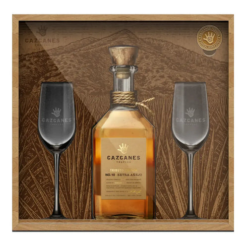 A collector set featuring Cazcanes No. 10 Extra Añejo Tributo Edition Tequila 750mL Gift Set (Pre-Order) with two elegant stemmed glasses, all from Cazcanes Tequila in a mountain-themed display.