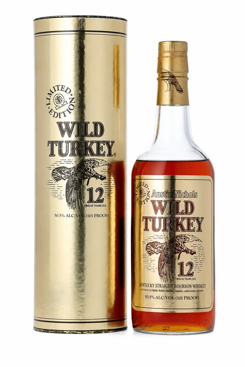A bottle of Wild Turkey 12 Year Old 1991 Gold Foil Kentucky Straight Bourbon Whiskey 750mL from Wild Turkey stands next to its striking gold cylindrical box. The label is adorned with a turkey illustration and notes its 50.5% ABV, making this vintage whiskey a coveted find for collectors and enthusiasts.