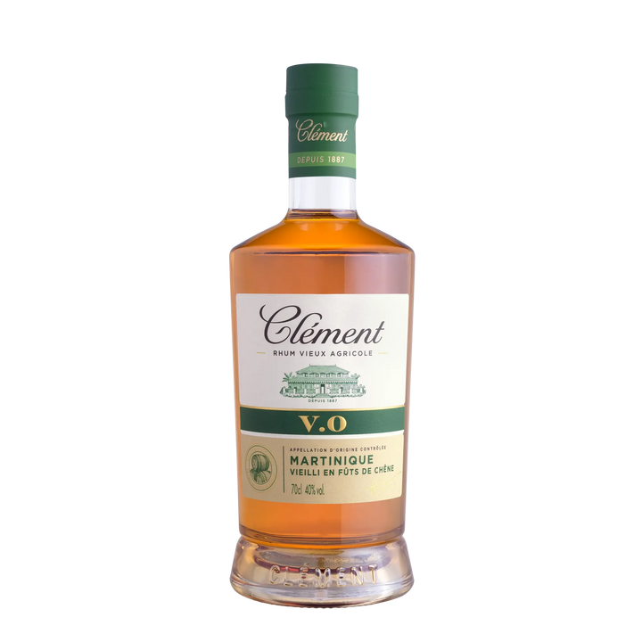 A bottle of Rhum Clément V.O from Martinique with a green cap, amber liquid, and a white label—crafted from sugarcane juice for an authentic Martinique rum experience.