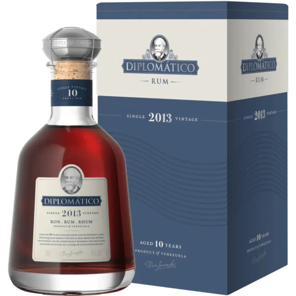 A bottle of Diplomático 2013 Single Vintage Rum by Diplomatico Rum, featuring a silver cap, stands next to its blue-gray box. The label shows “2013” and Aged 10 Years, emphasizing this premium Venezuelan aged rum.