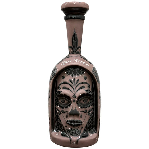 A stunning Dos Artes Día de los Muertos Calavera Extra Añejo Reserva Especial 36 Limited Edition 2026 (Pre-Order) tequila bottle by Dos Artes features a brown finish adorned with an intricate black and white skull face, elaborate patterns, and floral motifs on the front. This remarkable collectible vessel houses Extra Añejo tequila, making it a standout centerpiece for any enthusiast’s collection.