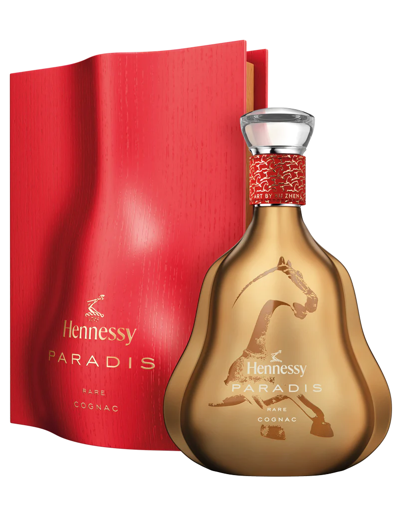 A gold Hennessy Paradis Rare Cognac Lunar New Year Limited Edition Art by Xu Zhen bottle with artistic designs stands before a textured red box, both featuring gold accents—capturing the luxury of this exclusive 2026 release.