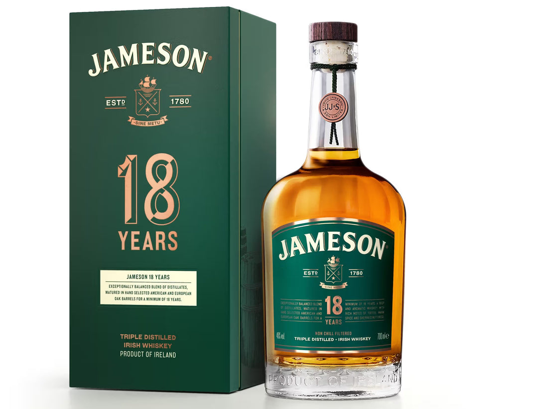 A bottle of Jameson 18 Years whiskey stands beside its green box, both displaying gold and white brand details. This smooth Jameson is aged in hand-selected oak casks, resulting in a rich amber hue.