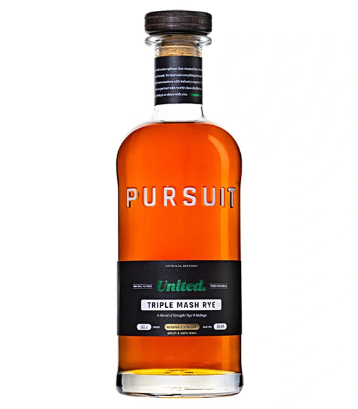 A clear glass bottle of Pursuit Spirits' Pursuit United Barrel Proof Triple Mash Rye Whiskey 700mL, filled with amber whiskey and sealed with a dark wooden cap. The label features black and green details highlighting this barrel proof rye.