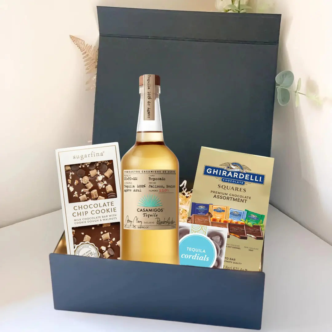 The Premium Tequila Gift Box by Main Street Liquor includes Casamigos tequila, Sugarfina chocolate chip cookie bites, Ghirardelli chocolate squares, and tequila cordials, all beautifully presented in a sleek black box.