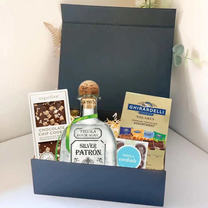 The Premium Tequila Gift Box by Main Street Liquor includes Patrón Silver, gourmet chocolate chip cookies, Ghirardelli chocolate squares, and tequila-flavored cordials in a sleek black box.