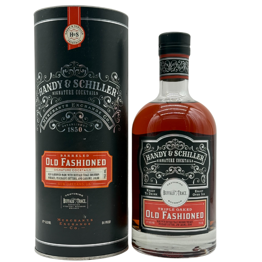 A bottle of Handy & Schiller Barreled Old Fashioned from Buffalo Trace sits beside its black cylindrical packaging, both sporting vintage-style labels with red, white, and silver details.