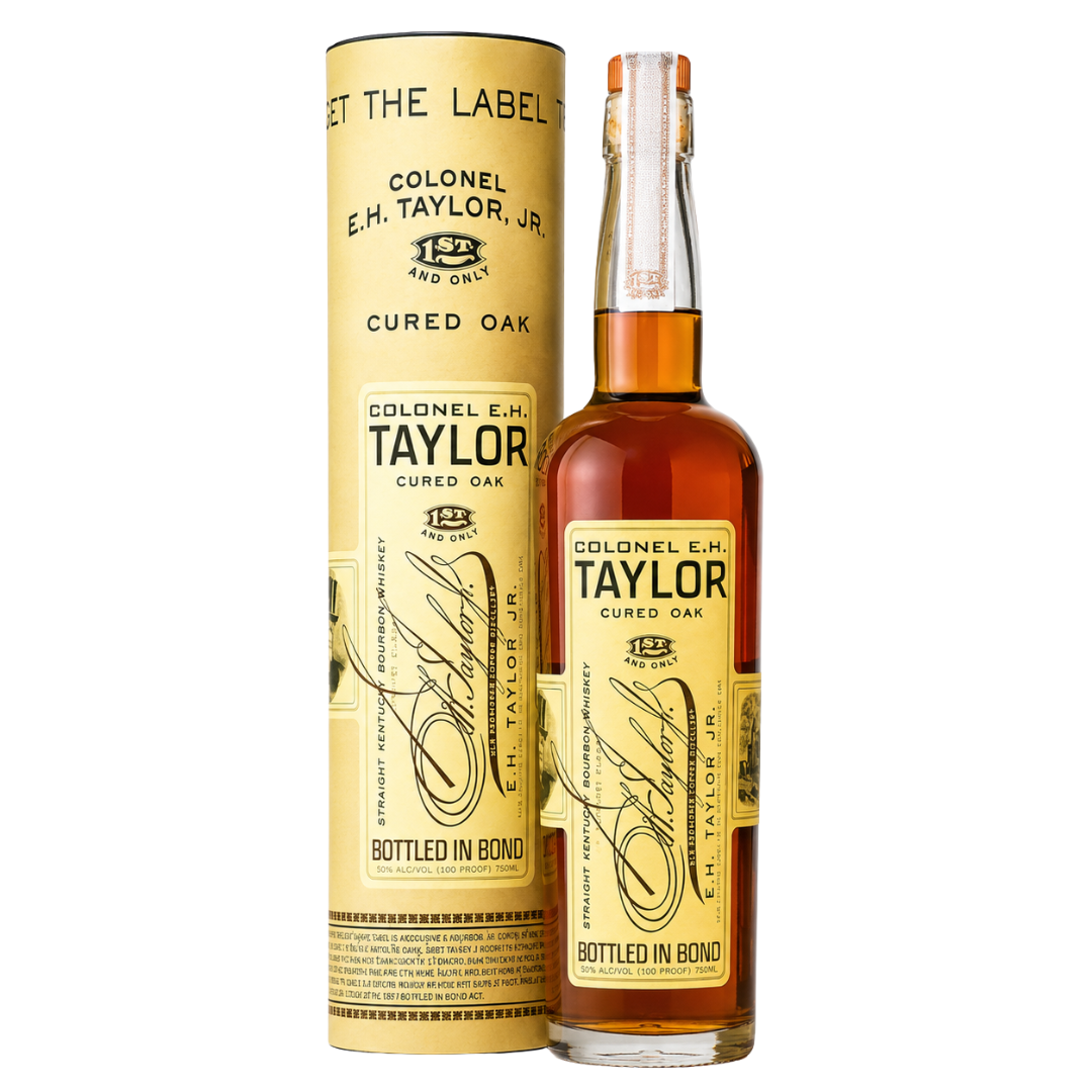 A bottle of Colonel E.H. Taylor, Jr. Cured Oak 2026 Release Bourbon Whiskey stands beside its matching cream and gold cylindrical box, both featuring black and gold text. The amber bourbon inside highlights the premium Colonel E.H. Taylor brand.