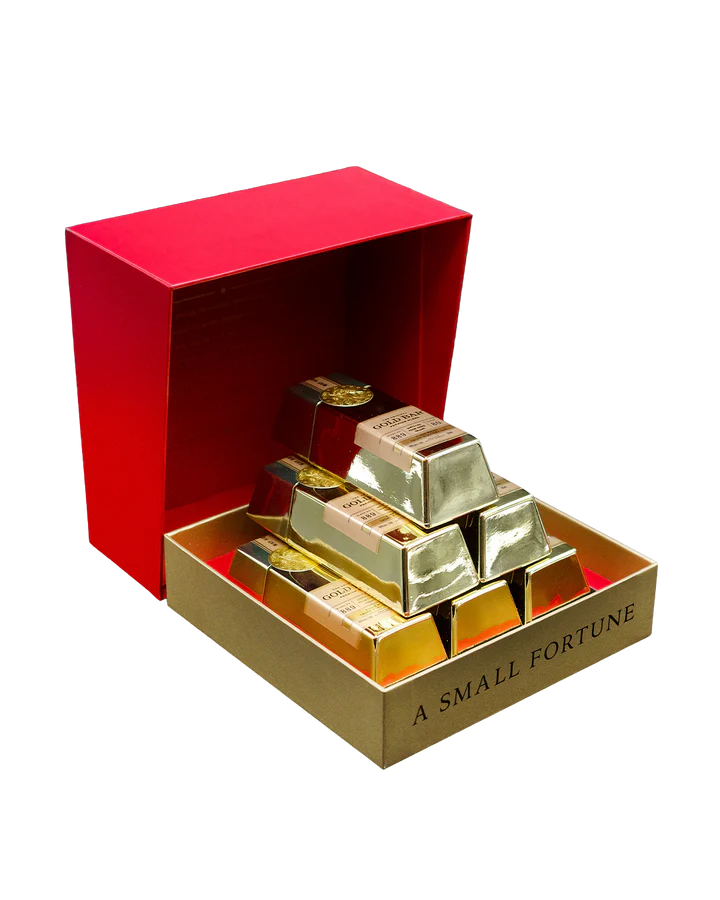 An open Gold Bar Small Fortune Gift Set from Main Street Liquor reveals stacked, individually wrapped chocolate bars, inspired by mini whiskey bottles and treasures aged in Napa wine barrel-finished style.
