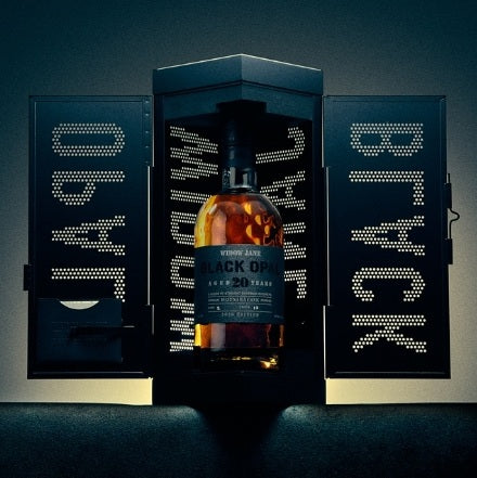 A bottle of Widow Jane Black Opal 20 Year Mizunara Oak Finished Bourbon 99 Proof 750mL inside a black, cabinet-style display box with perforated letters on the open doors.