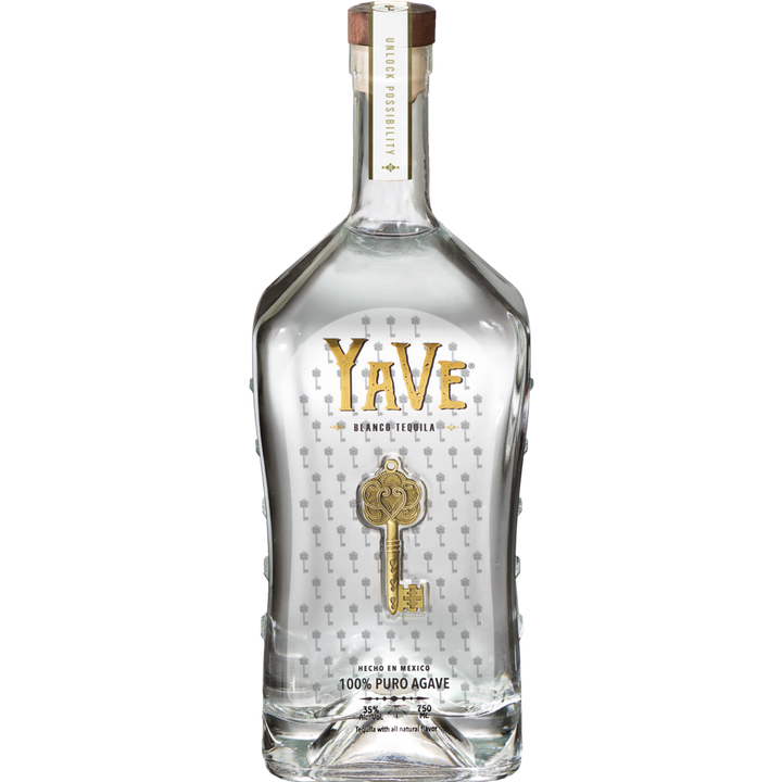 A clear glass bottle of YaVe Tequila Blanco, featuring bold gold "YaVe Tequila" branding and a gold key design. This handcrafted, ultra-smooth tequila with a wooden cap is crystal clear—ideal for your next margarita.