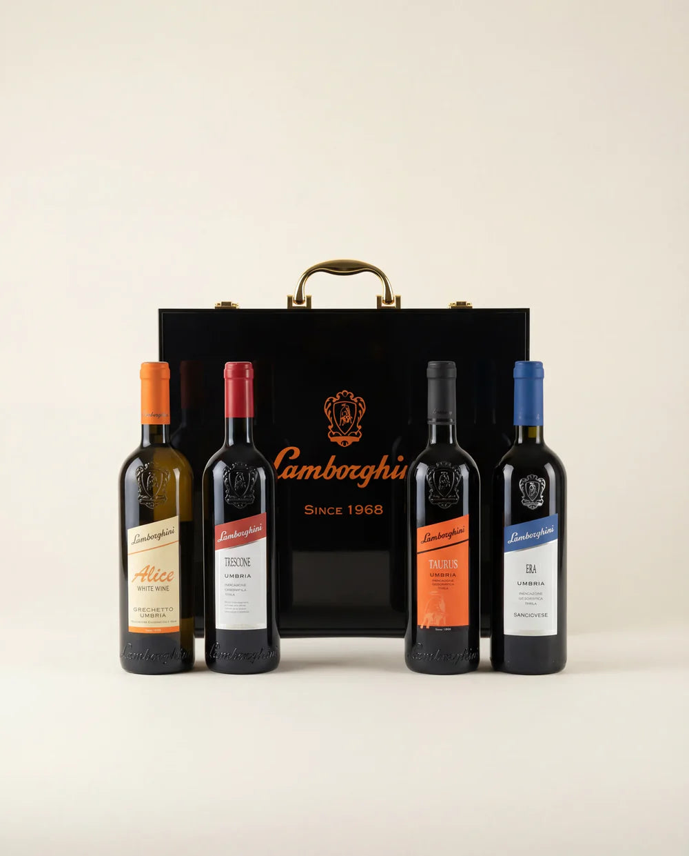 The Lamborghini Ultimate Wine Gift Set—Trescone, Era, Taurus, and Alice—is displayed before a black luxury gift case with gold handles featuring the Lamborghini Wine & Spirits Collections logo and "Since 1968".