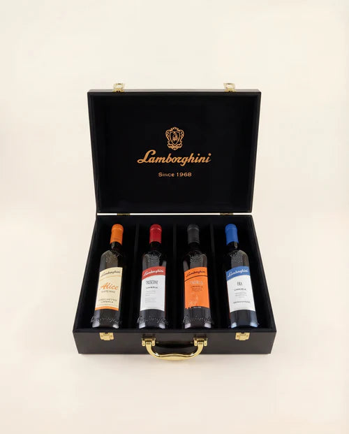 The Lamborghini Ultimate Wine Gift Set by Lamborghini Wine & Spirits Collections features four wines—Trescone, Era, Taurus, and Alice—in a black luxury gift case with gold accents, each bottle sporting a unique label for an exquisite Italian present.