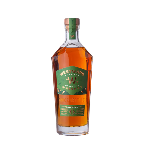 A bottle of Westward American Single Malt Rum Cask by Westward, with a green and gold label, wooden cap, and amber whiskey inside, is shown against a plain white background.